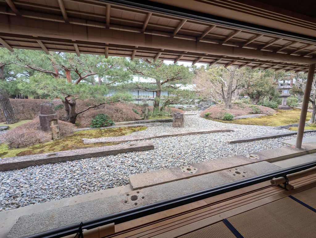 京都迎賓館の深い軒下の回廊から眺める、飛び石と松の木が美しく配置された和の庭園