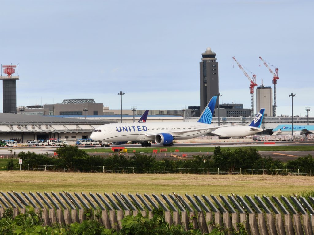 さくらの山公園から撮影した、青い地球儀の尾翼ロゴが目印のユナイテッド航空の機体と成田空港の風景